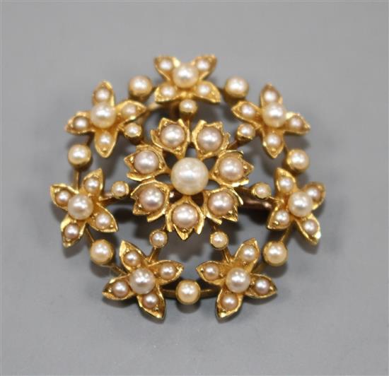 An Edwardian yellow metal and split pearl set flower head pendant brooch, 27mm.